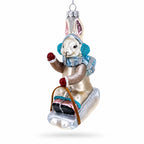 Bunny Sledding with Earmuffs Glass Christmas Ornament by BestPysanky